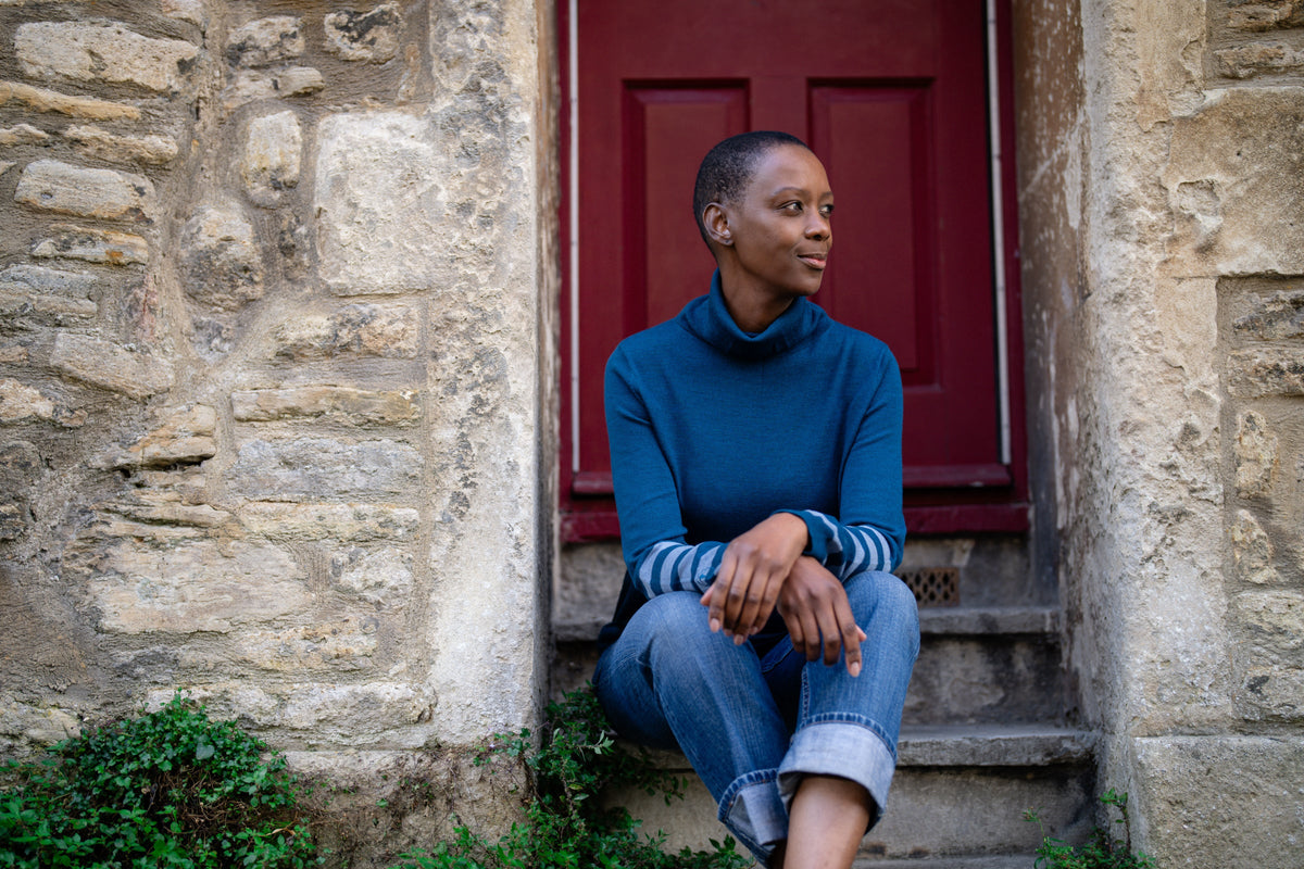 Woman sitting on stone steps outside a building