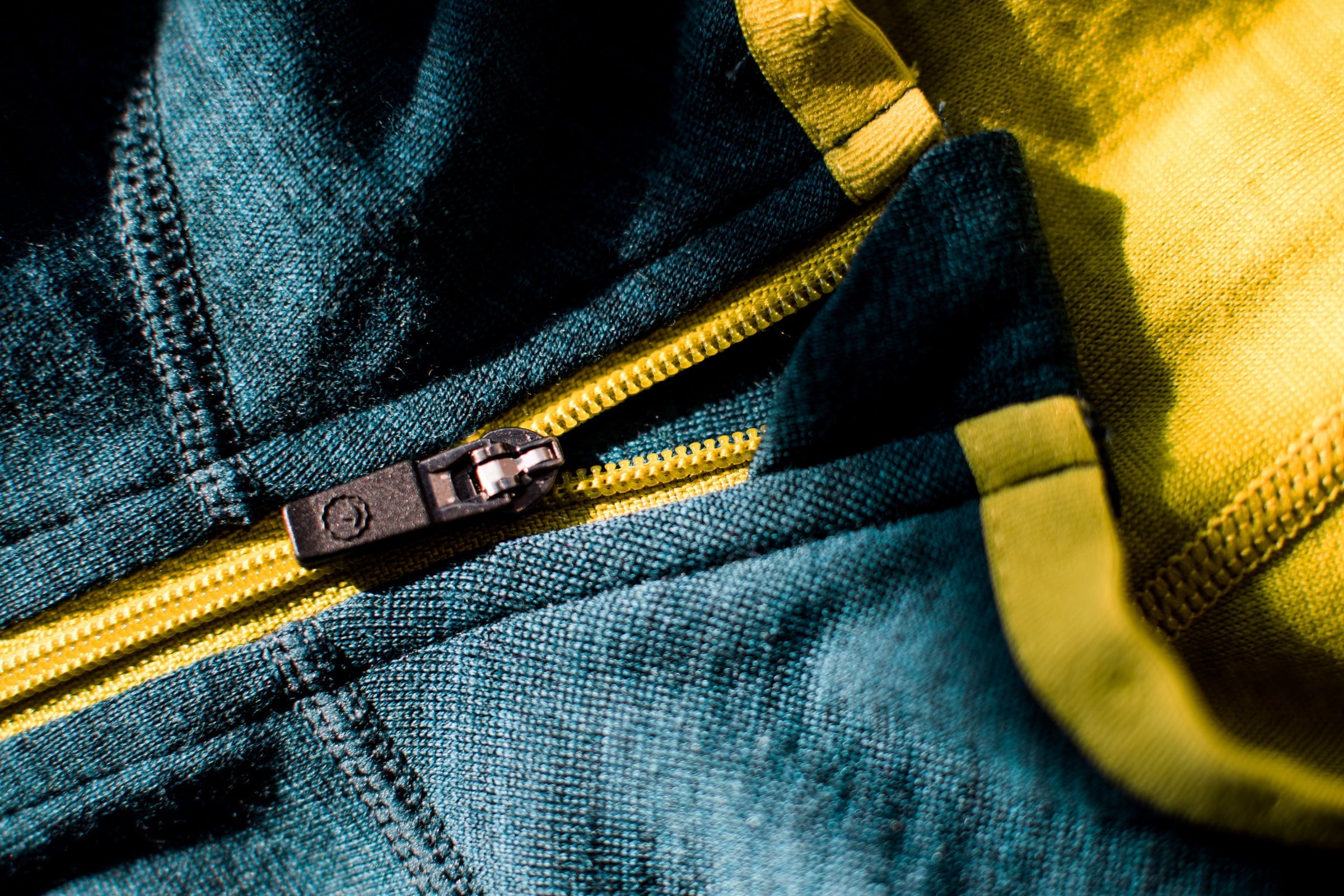 Close-up of Merino wool fabric with a lime zip and visible stitching details